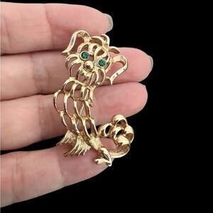 Vintage gold tone Avon dog brooch with green eyes stamped